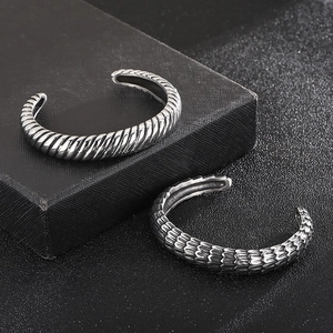 Detailed close-up of retro silver dragon scale and twisted rope pattern bangles