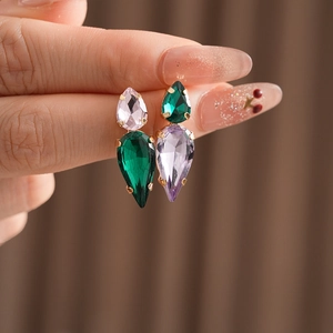 Detail of waterdrop zircon earrings with green and pink stones in gold setting
