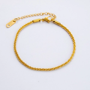 Detailed close-up of golden spiral twisted Cuban link chain with adjustable lobster clasp