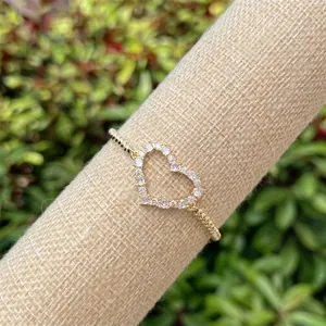 Macro shot of gold plated heart ring with sparkling pave set white cubic zirconia stones