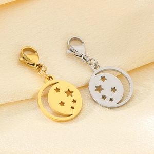 Detailed view of gold and silver moon and star hollow charms on soft yellow silk background