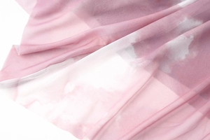 Detail of pink and white tie-dye mesh fabric featuring elegant pleats and soft texture