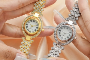Dettaglio di orologi al quarzo oro e argento con cristalli su elegante tessuto di seta