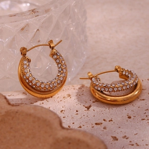 Macro detail of 18K gold plated hoop earrings with micro-inlaid clear crystals