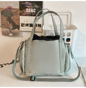 Detail of light green waterproof nylon tote bag with drawstring closure and shoulder strap