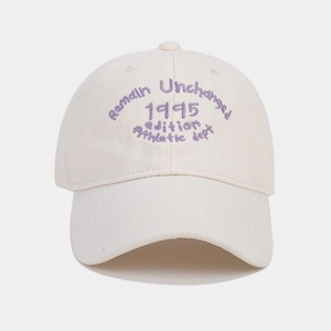 Dettaglio del ricamo sportivo vintage su un cappellino da baseball in tela crema