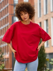 Λήψη δρόμου από ένα κόκκινο βαμβακερό oversized T-shirt σε συνδυασμό με ανοιχτό μπλε τζιν