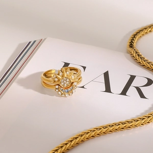 Detail of gold moon and sun stackable rings with blue and white crystals on a magazine