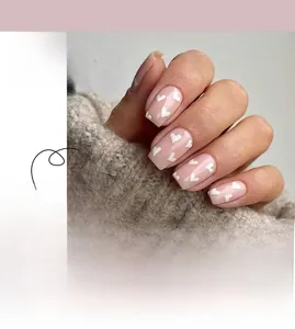 Detail of JP2251 press-on nails featuring nude pink base and white heart patterns