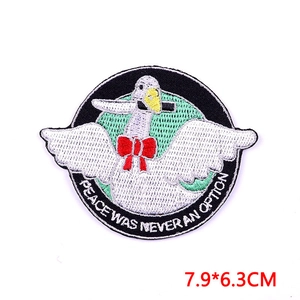 Detail van een witte ganzenborduurpatch met mes en rode strik voor kinderkleding