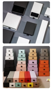 Detail of multi-colored drawer jewelry boxes showing silk ribbon pulls and black inserts
