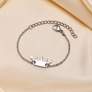 Polished stainless steel crown pendant bracelet on champagne silk, adjustable length