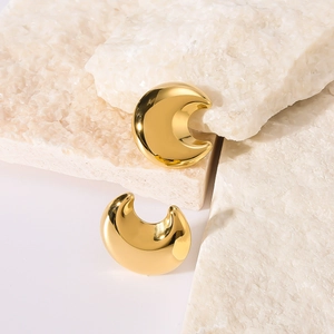 Polished golden stainless steel crescent hoop earrings on minimalist stone background