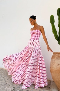Detailed view of tiered white strapless dress with pink polka dots and bow detail