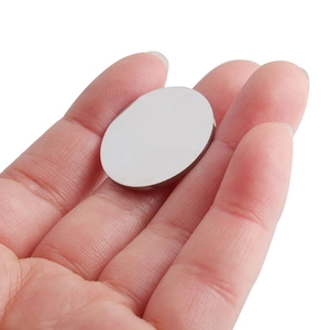 Pendentif rond en acier inoxydable poli sur une main montrant sa taille réelle et son fini