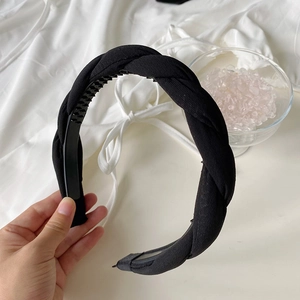 Detail of black braided twist headband showing non-slip inner teeth and padded fabric