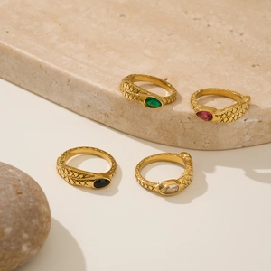 Detail of four 18k gold-plated snake rings with emerald, ruby, and black zircon stones