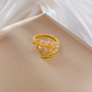 Gold leaf shaped open ring with marquise zircon stones on smooth satin background