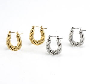 Detail of twisted U-shape hoop earrings in polished gold and silver stainless steel
