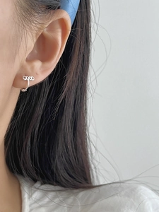 Detail view of mini 925 silver hoop earring with engraved GOOD letter design on model ear