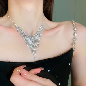Detail of silver V-shaped rhinestone tassel necklace with sparkling fringe on model
