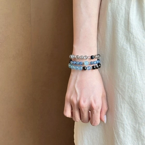 Natural Moonstone and Obsidian beaded bracelet set worn by a model in a minimal style