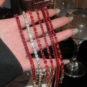 Detailed view of tennis bracelets with ruby red and white stones in 18k gold plating