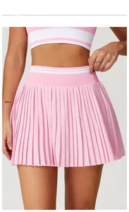 Light pink tennis set detail showing pleated mini skirt and matching tank top with stripes
