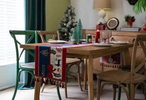 Close-up of festive jacquard table runner with Christmas tree patterns and tassel detail