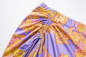Dettaglio del costume floreale con tessuto viola e design con coulisse arricciata