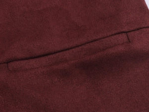 Close-up of deep red faux suede fabric showing detailed stitching and soft plush texture
