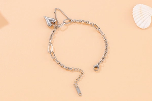 Détail macro du bracelet en acier argenté avec pendentif cœur et gravure S-STEEL