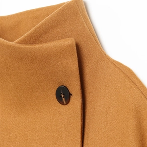 Detailed macro view of caramel wool coat collar and black tortoiseshell buttons