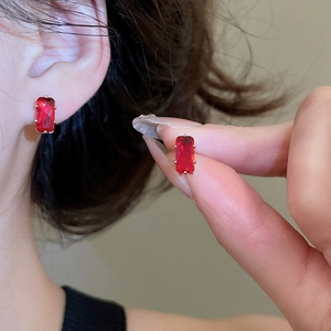 Macro detail of rectangle red zircon stud earring with silver claw setting for women