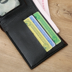 Detail of black lychee grain leather wallet with multiple card slots on a wooden background