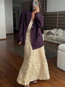 Detail of elegant cream maxi skirt with 3D floral texture and dark purple blazer jacket