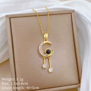 Detail of moon tassel necklace with crystal pavé and black stone in a jewelry box