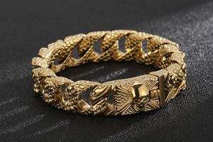 Macro detail of golden stainless steel skull bracelet featuring textured snake scale links