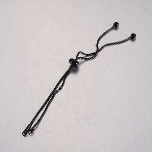Macro detail of adjustable black stainless steel bolo chain with sliding stopper bead