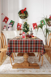 Close-up of red and green plaid festive tablecloth with tassels on a rustic table
