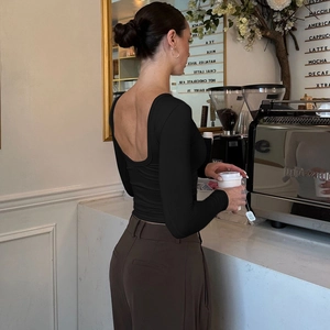 Dettaglio del top nero aderente a maniche lunghe con elegante design con schiena scoperta a U