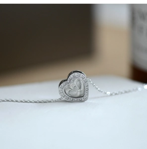 Macro shot of silver heart pendant with shimmering rhinestones and inner ray texture