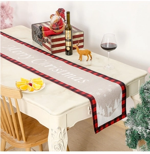 Détail du chemin de table de Noël avec motifs de rennes et bordures à carreaux rouges décor