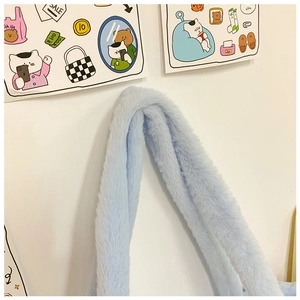 Close-up of fluffy light blue plush shoulder strap on a cute cartoon-style handbag