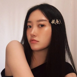 Elegant black oval hair clip with silver floral pattern worn on model side hair