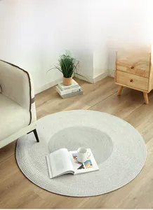 Detail eines grau-weiß gewebten Baumwollteppichs mit Spiralmuster im Wohnzimmer-Ambiente