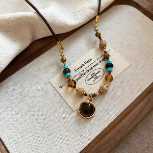 Close-up of tiger eye stone pendant on beaded necklace with retro bohemian style