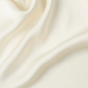 Macro view of creamy white satin fabric showing soft texture and fine twill grain