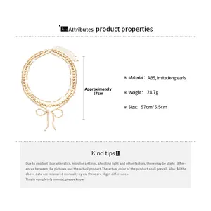 Detailed view of layered gold beads and pearl necklace with a delicate bow design