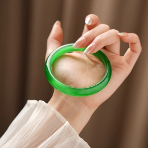 Macro detail of translucent green cat-eye stone bangle with elegant textured natural veins